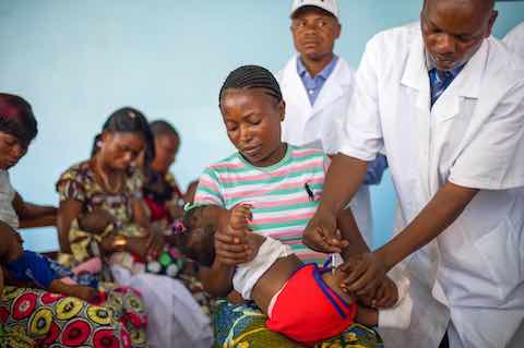 Four month old Ika Mafulu is held by her mother, Mukuko Mbana, as she is given a polio vaccine in a newly opened health centre in Mbankana, some 150km from Kinshasa, in the Democratic Republic of the Congo on April 28, 2015.